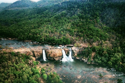 A panoramic view of multiple waterfalls flowing into a serene valley.