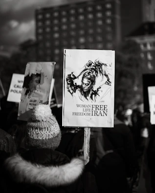 A close-up of a young Iranian woman holding a candle during a peaceful protest at dusk.