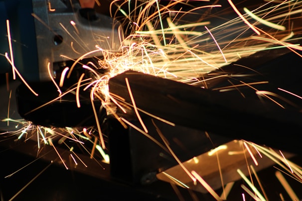 Dynamic shot of a laser beam cutting through thick steel, sparks flying in a dark environment.