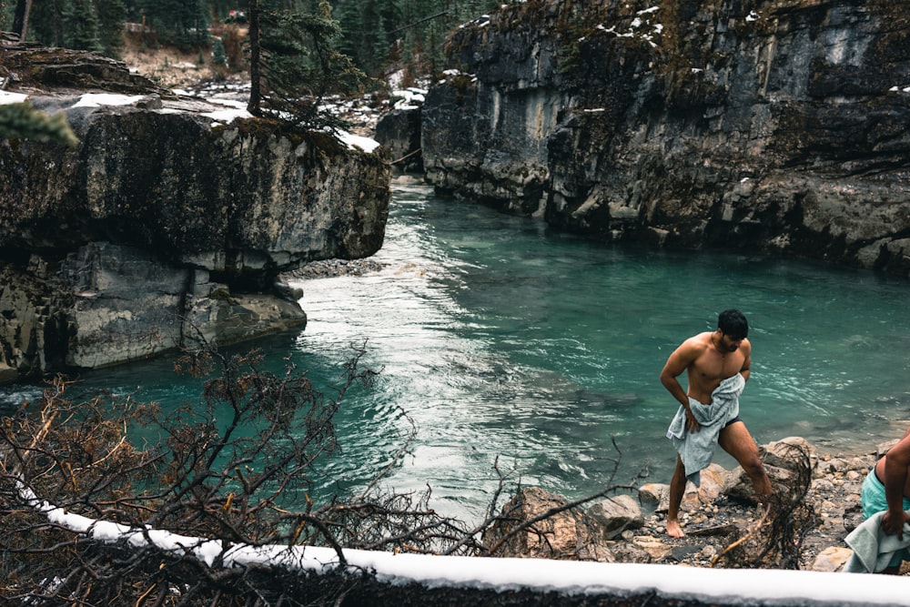 Ein Mann steht auf einem Felsen in einem Fluss