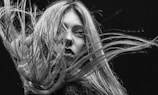 Black and white portrait of a woman with flowing hair and intense gaze