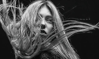 An evocative black-and-white portrait of a woman mid-performance, her expression fierce and soulful.