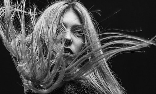 Black and white portrait of a woman in a bustling market, capturing raw emotion
