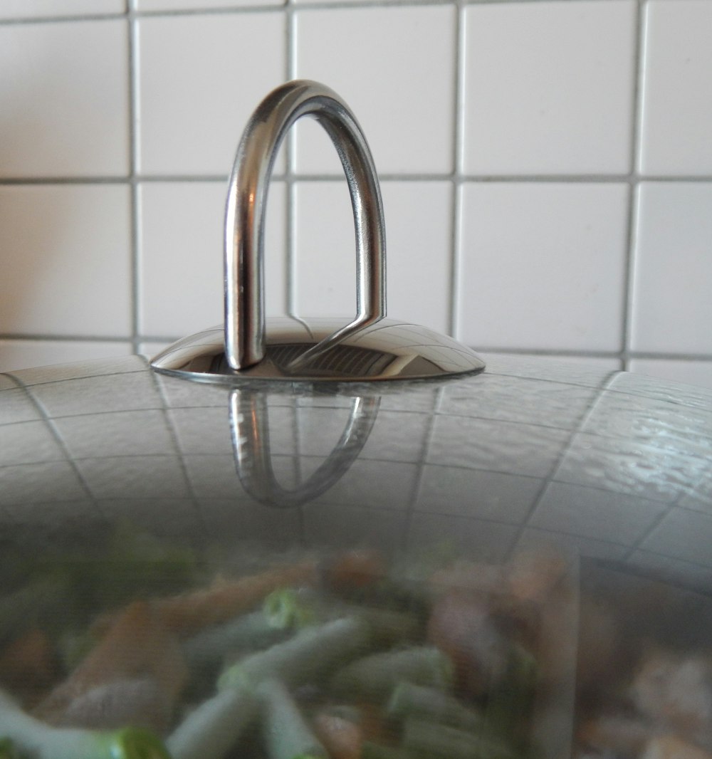 a metal faucet on a tile wall