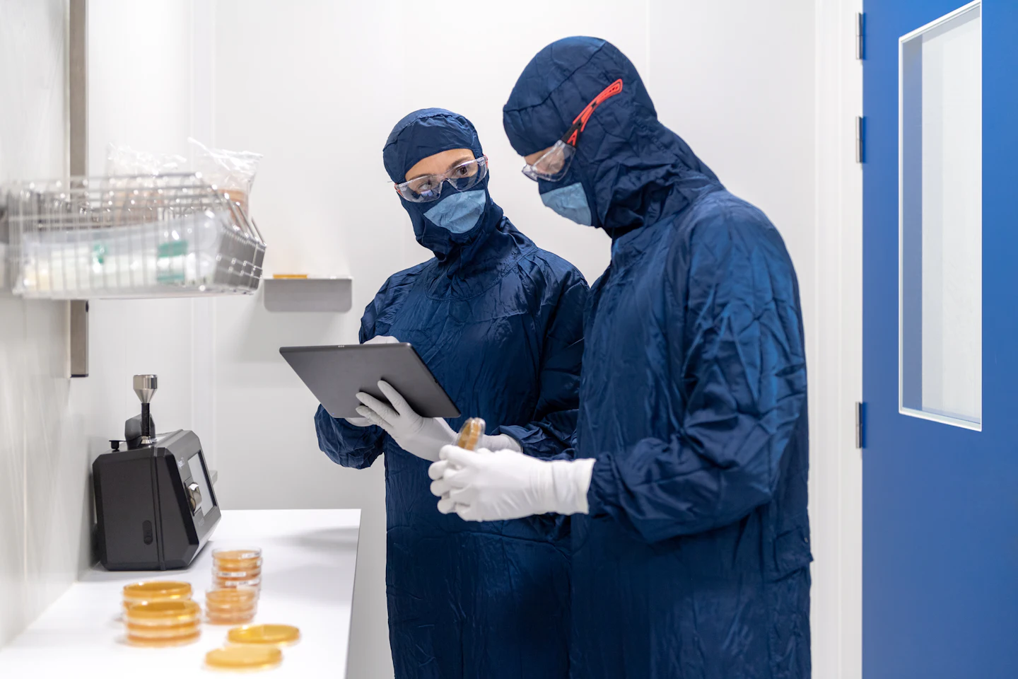 Technicians in gowns and gloves on a clean production floor