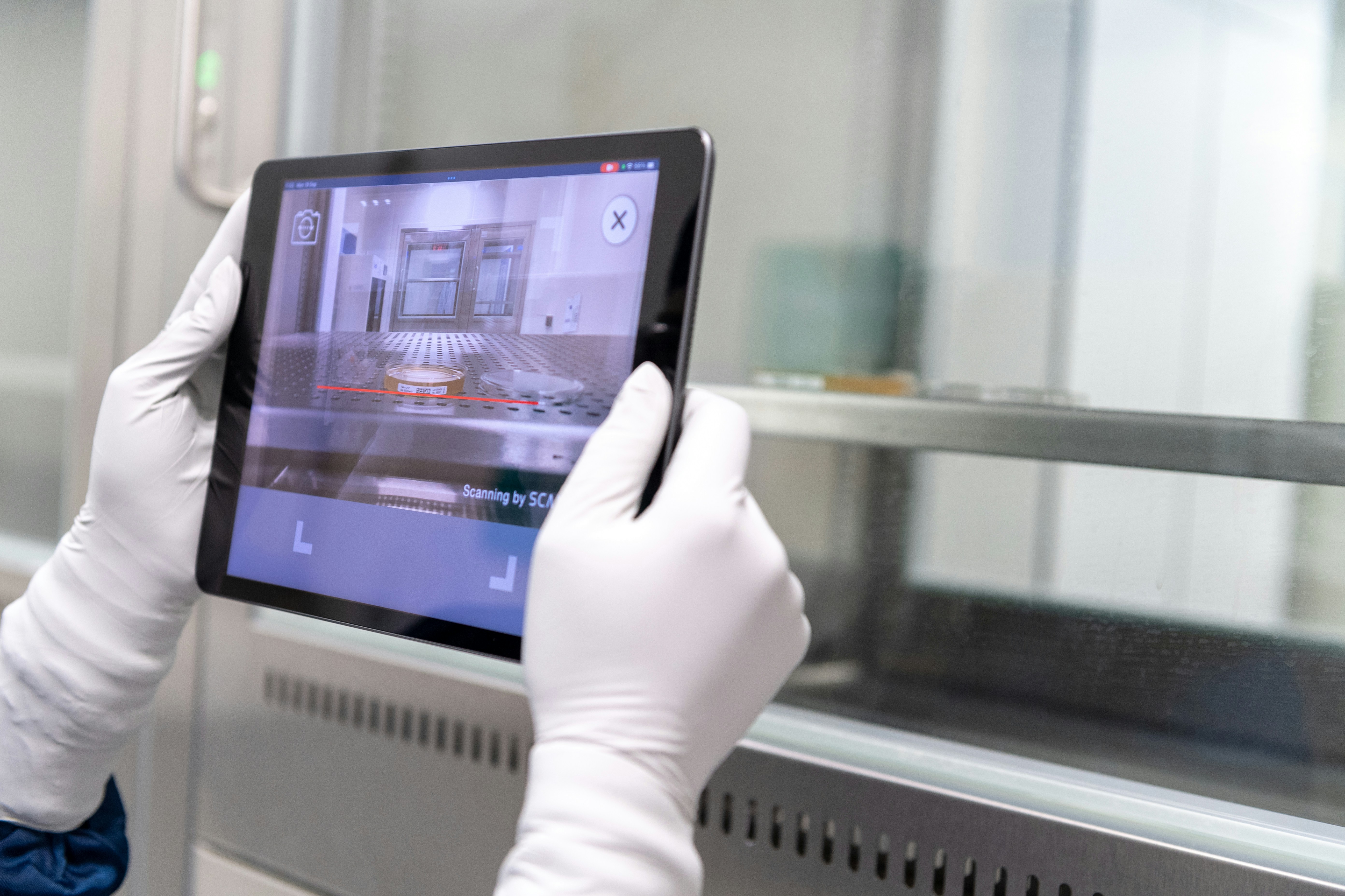 technician testing flexible oled display in cleanroom lab