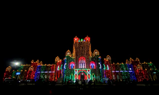 A nighttime scene of the Guanajuato government building illuminated with red and black lights.