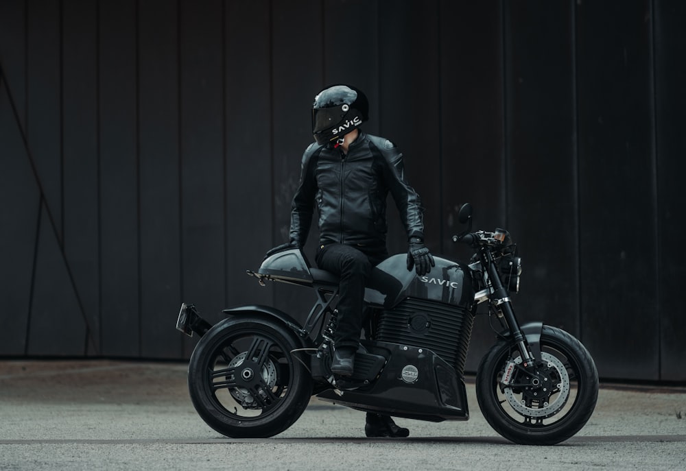 um homem em uma jaqueta de couro preta em uma motocicleta