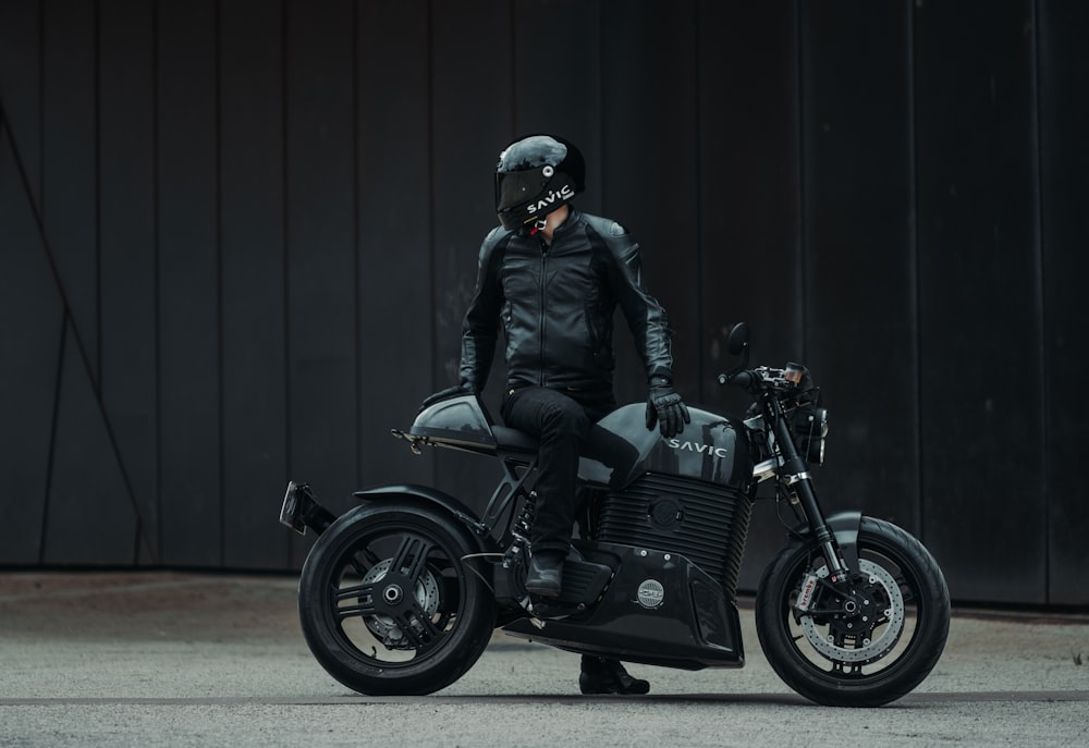 a man in a black leather jacket on a motorcycle