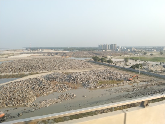 Environmental consultant reviewing project plans outdoors near a construction site.