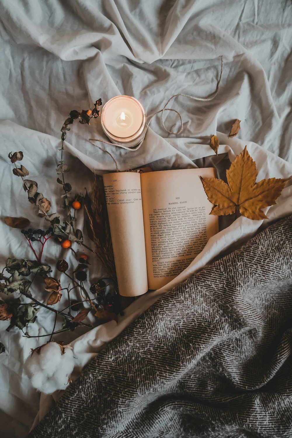 a book and a candle on a bed