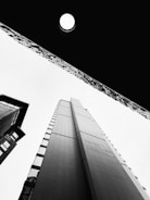 a moon in the sky above a couple of tall buildings