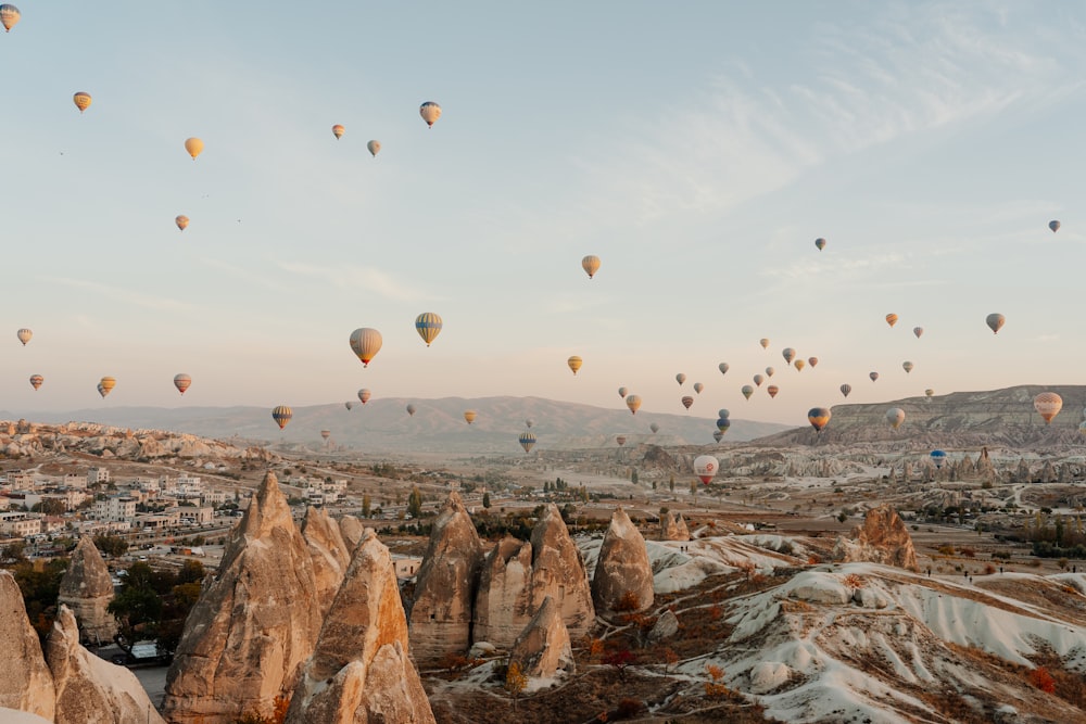 a group of hot air balloons in the sky with Cappadocia in the background