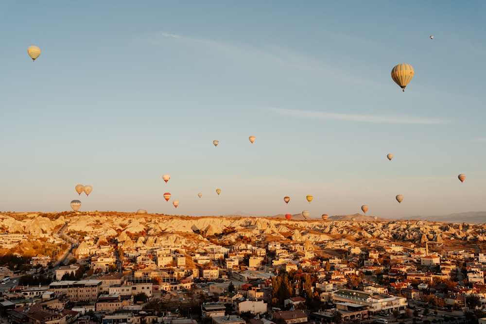 Un grupo de globos aerostáticos en el cielo sobre una ciudad