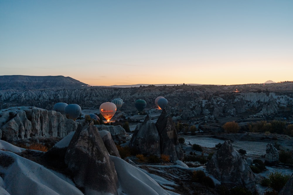 Un paisaje con rocas y un cuerpo de agua con una puesta de sol