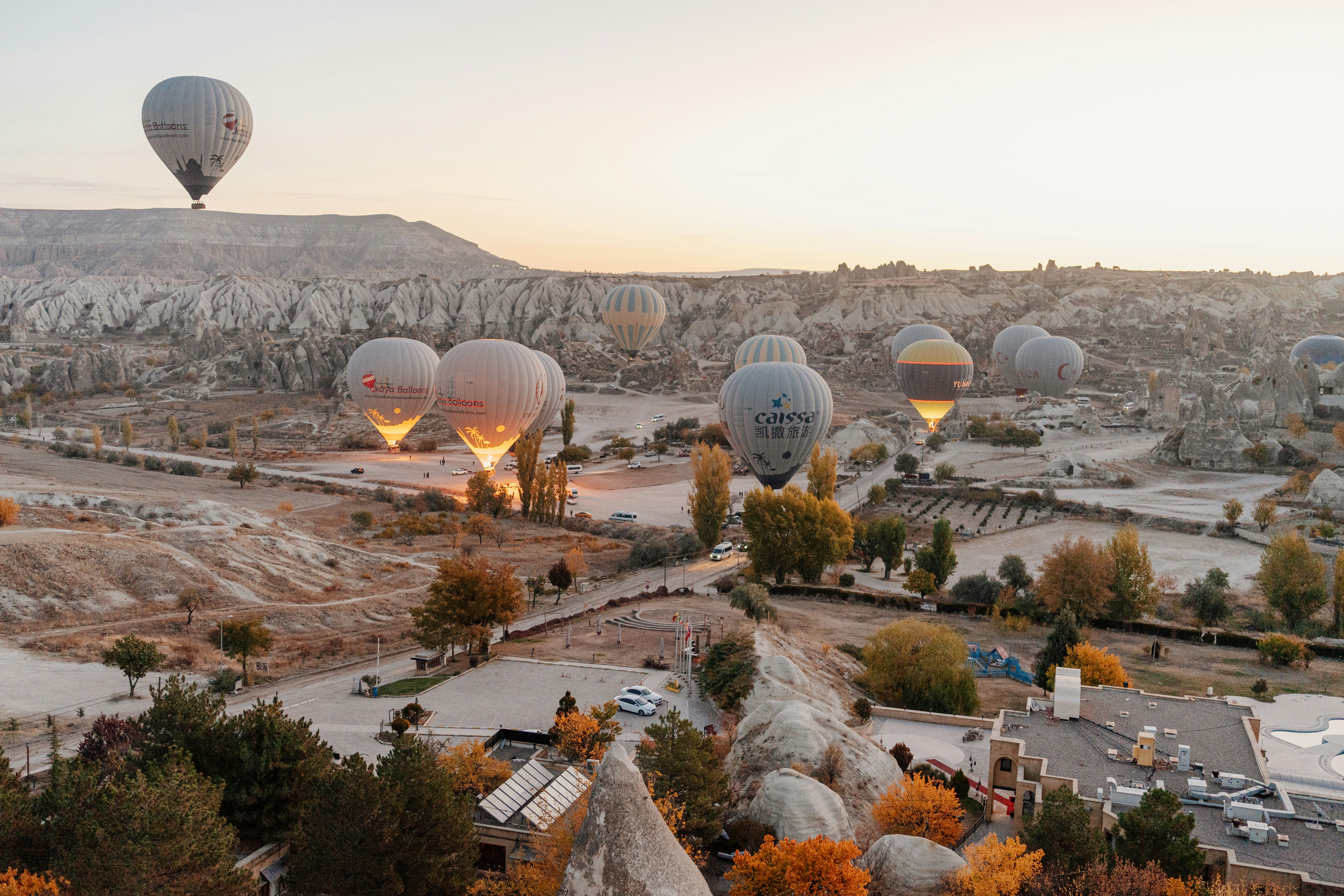 a group of large white and black hot air balloons above a city