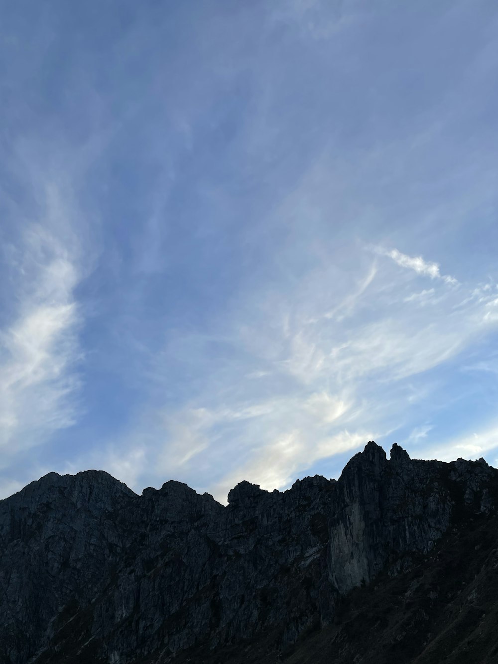 a rocky mountain with a blue sky