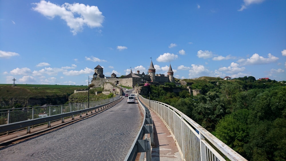 a road with a car on it and a castle in the background