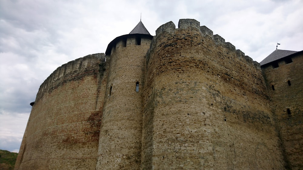 a stone castle with a cloudy sky