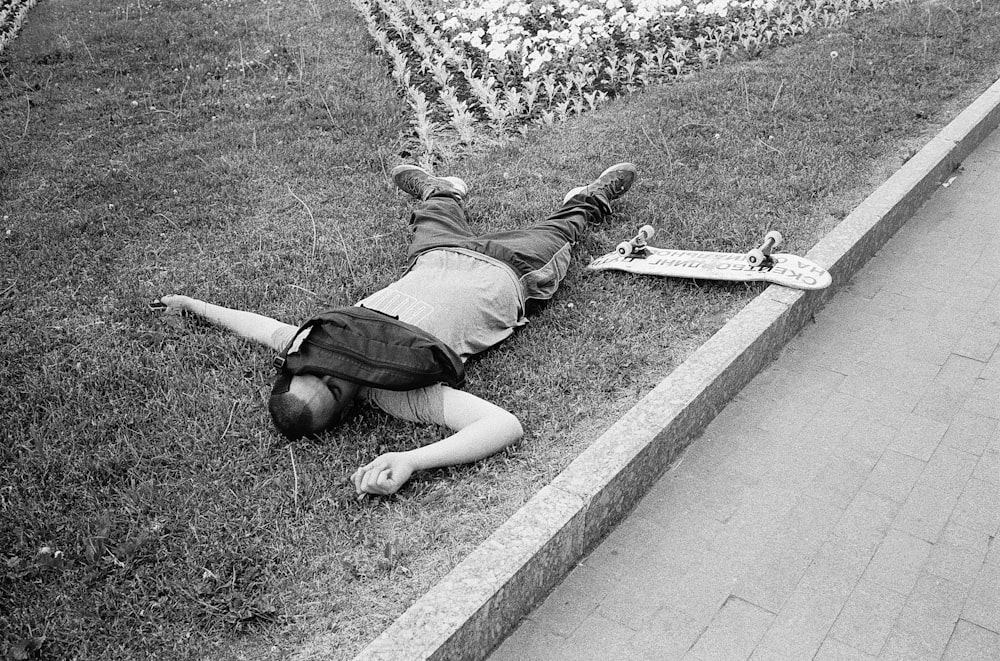 a person lying on the ground next to a skateboard
