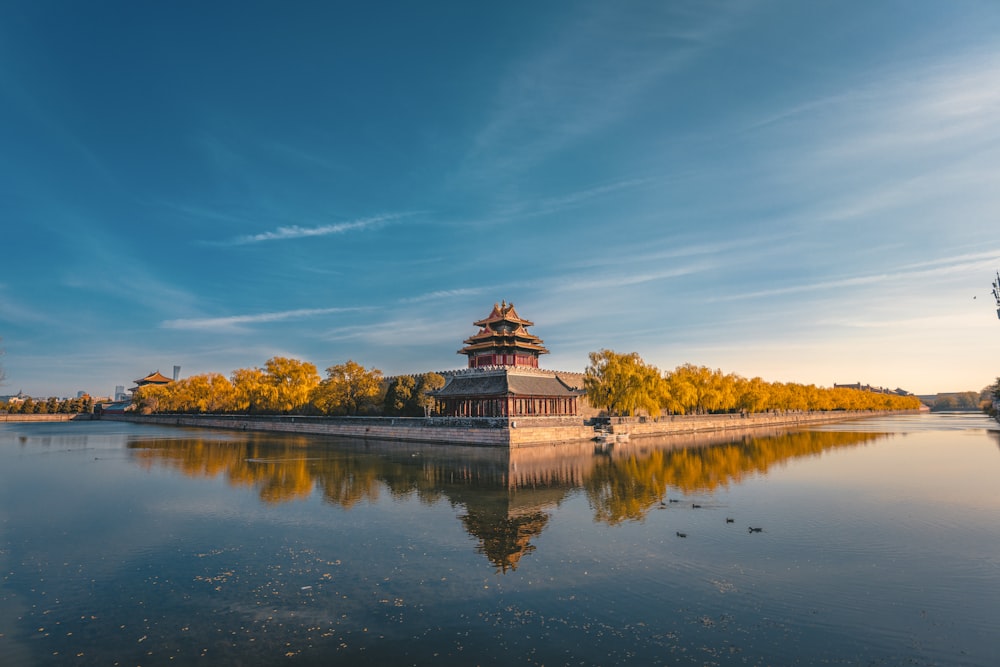 a building on a hill by a body of water