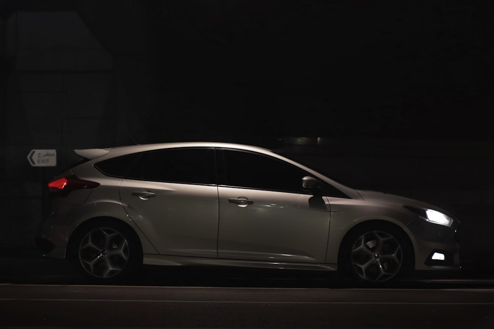 a silver car parked in a dark room