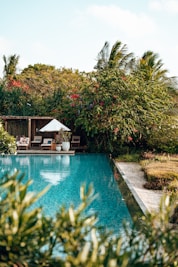 a pool with a gazebo and chairs by it