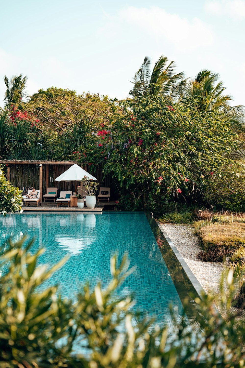 a pool with a gazebo and chairs by it