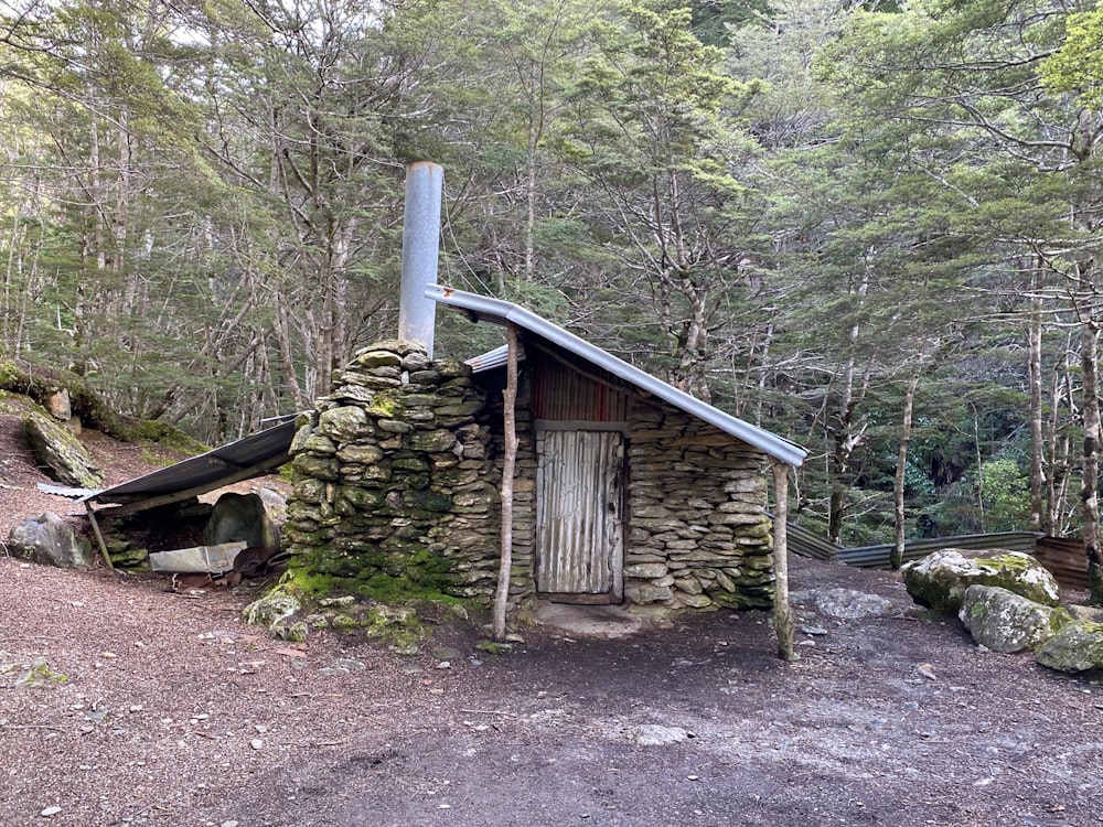 a stone building with a door and windows surrounded by trees