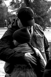 Photo of a family happily embracing in front of their home, symbolizing security and protection.