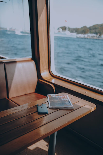 a table with a phone and a window with a view of the ocean