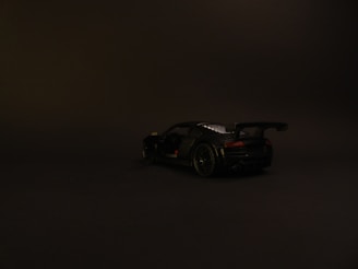 A minimalist car wallpaper highlighting a sleek sports car under soft lighting on a dark background.