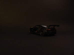 Side silhouette of the race car under dramatic lighting on a black background.