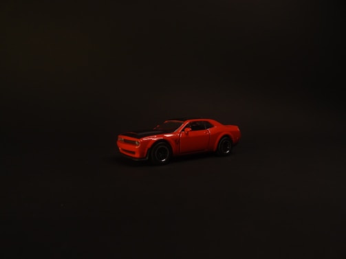 A shiny sports car parked against a dark backdrop highlighting the premium exterior detail work.