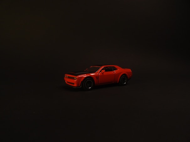 Sleek red luxury sports car parked against a white minimalist backdrop