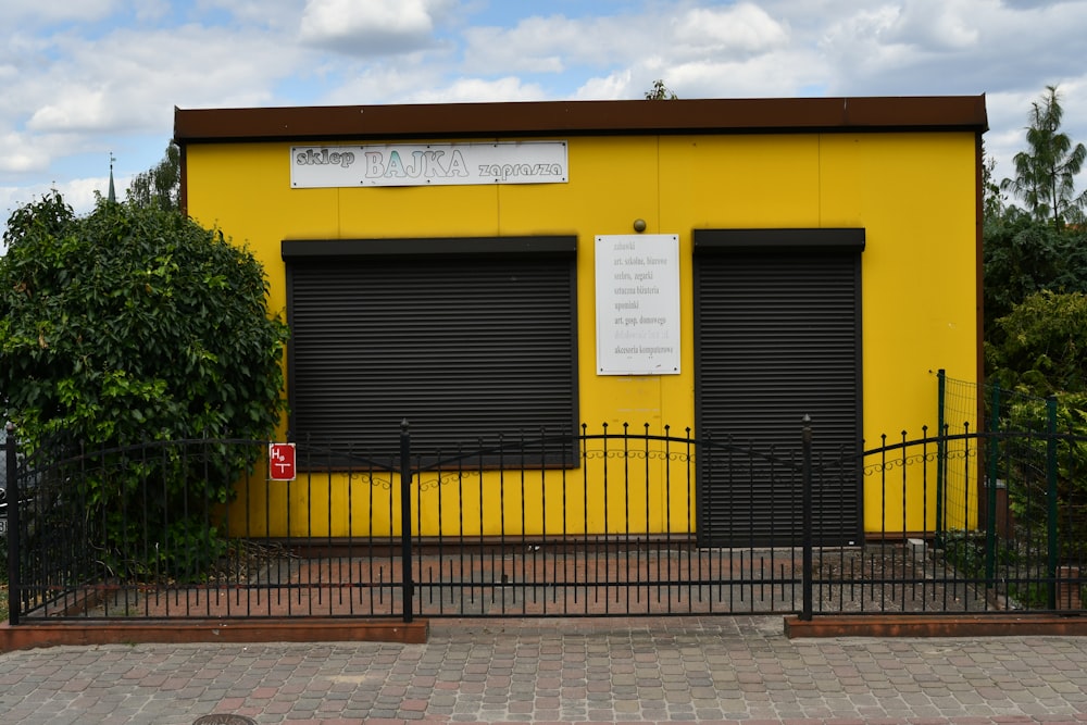 a yellow building with black gate