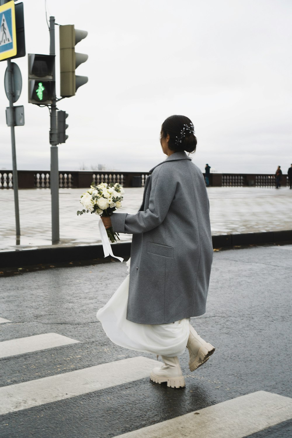 a person walking down the street holding flowers