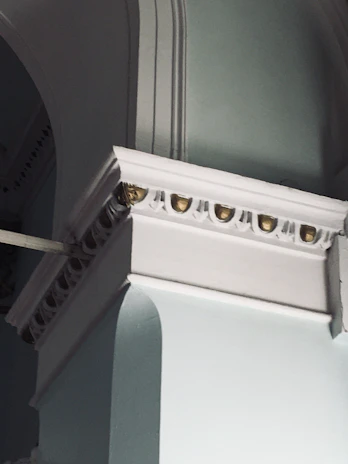 Close-up of elegant architectural details in metallic gold and deep navy blue tones.