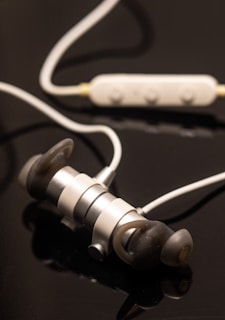 A user effortlessly controlling music playback with touch operation on the eynew earphones during a web conference.