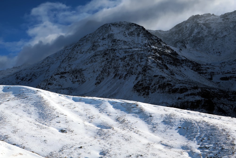 a snowy mountain with a trail