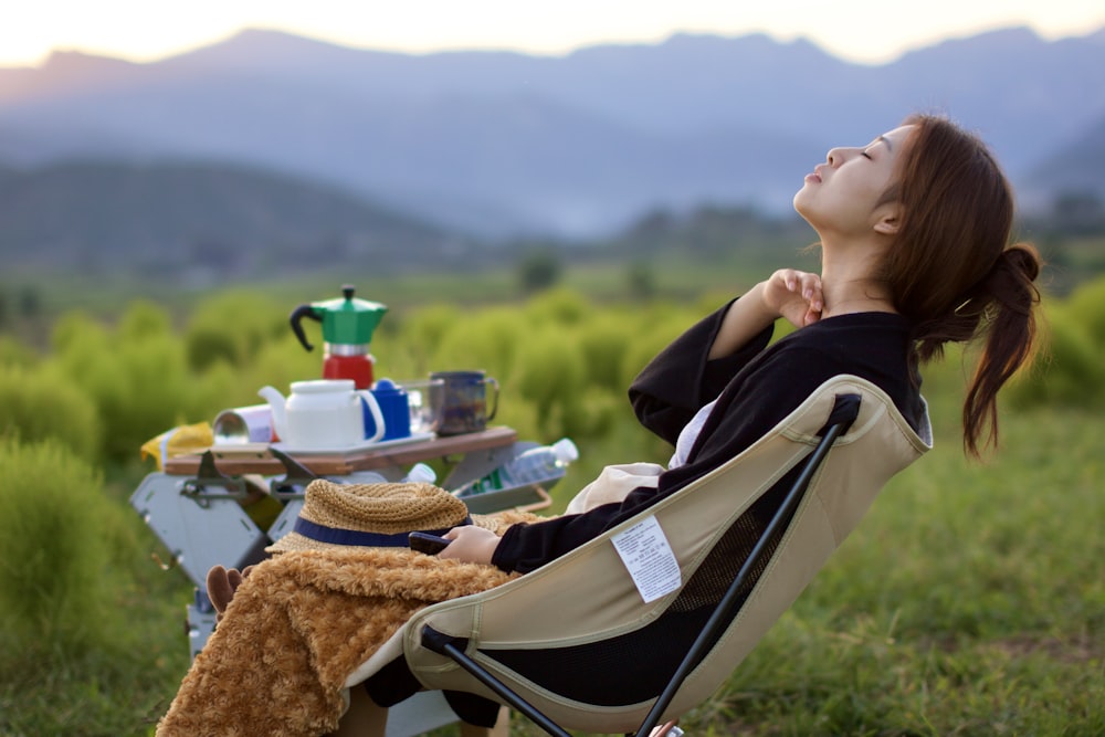 a woman sitting in a chair outside