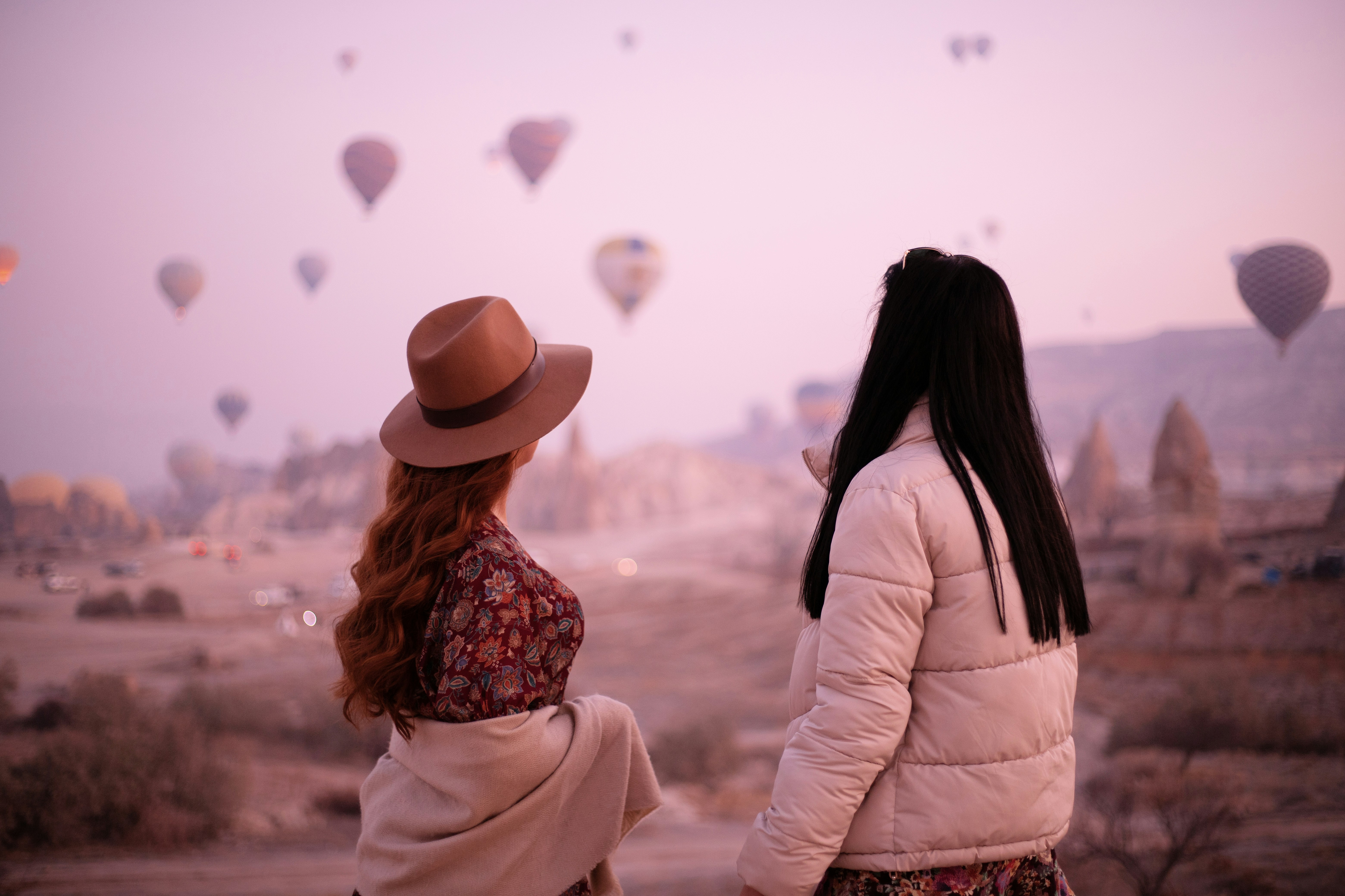 two women looking at a hot air balloon in the sky