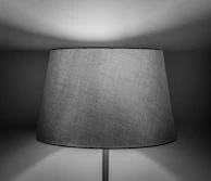 Close-up of a glowing pendant lamp casting intricate shadows on a textured wall.