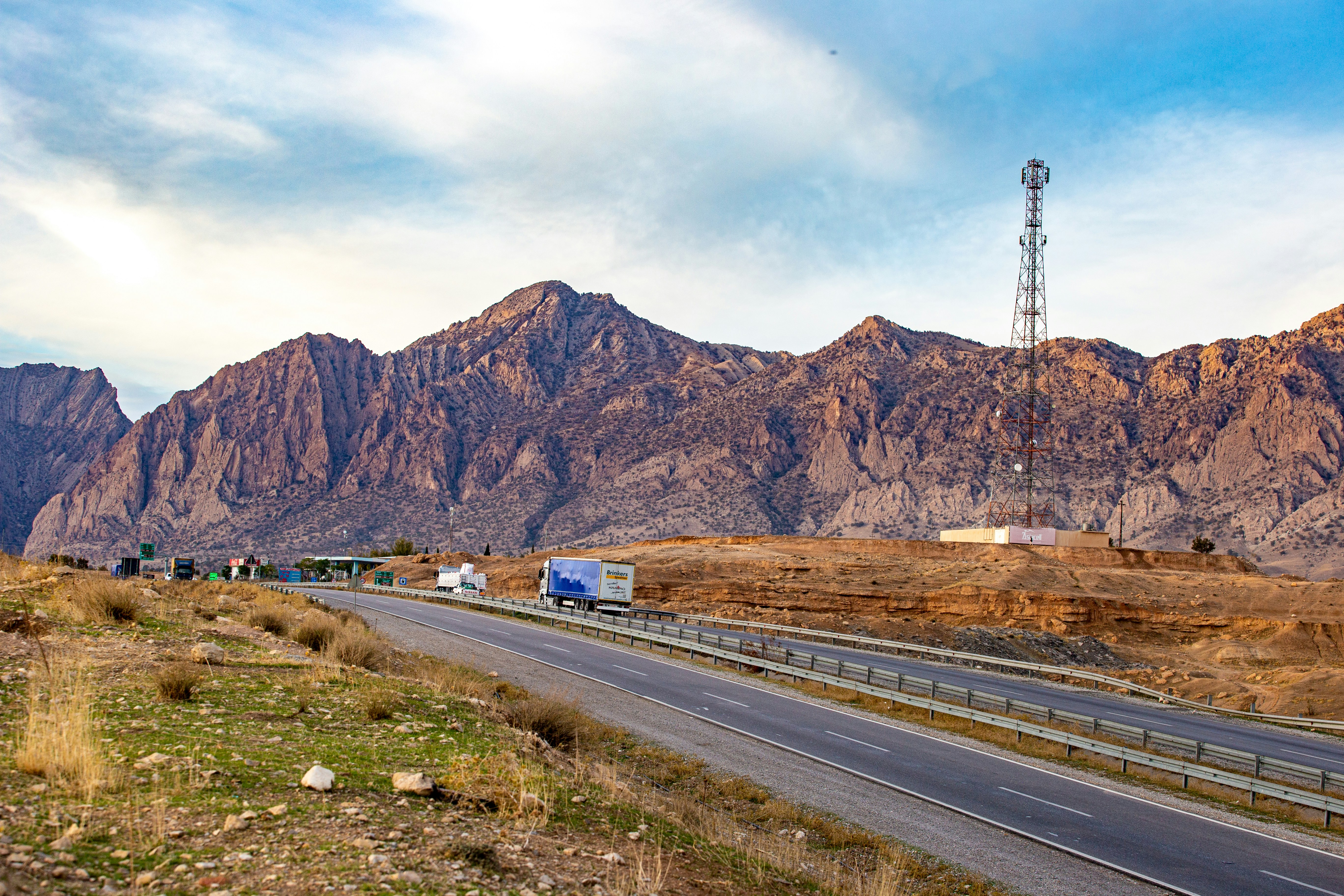 a road with a truck on it and a mountain in the background