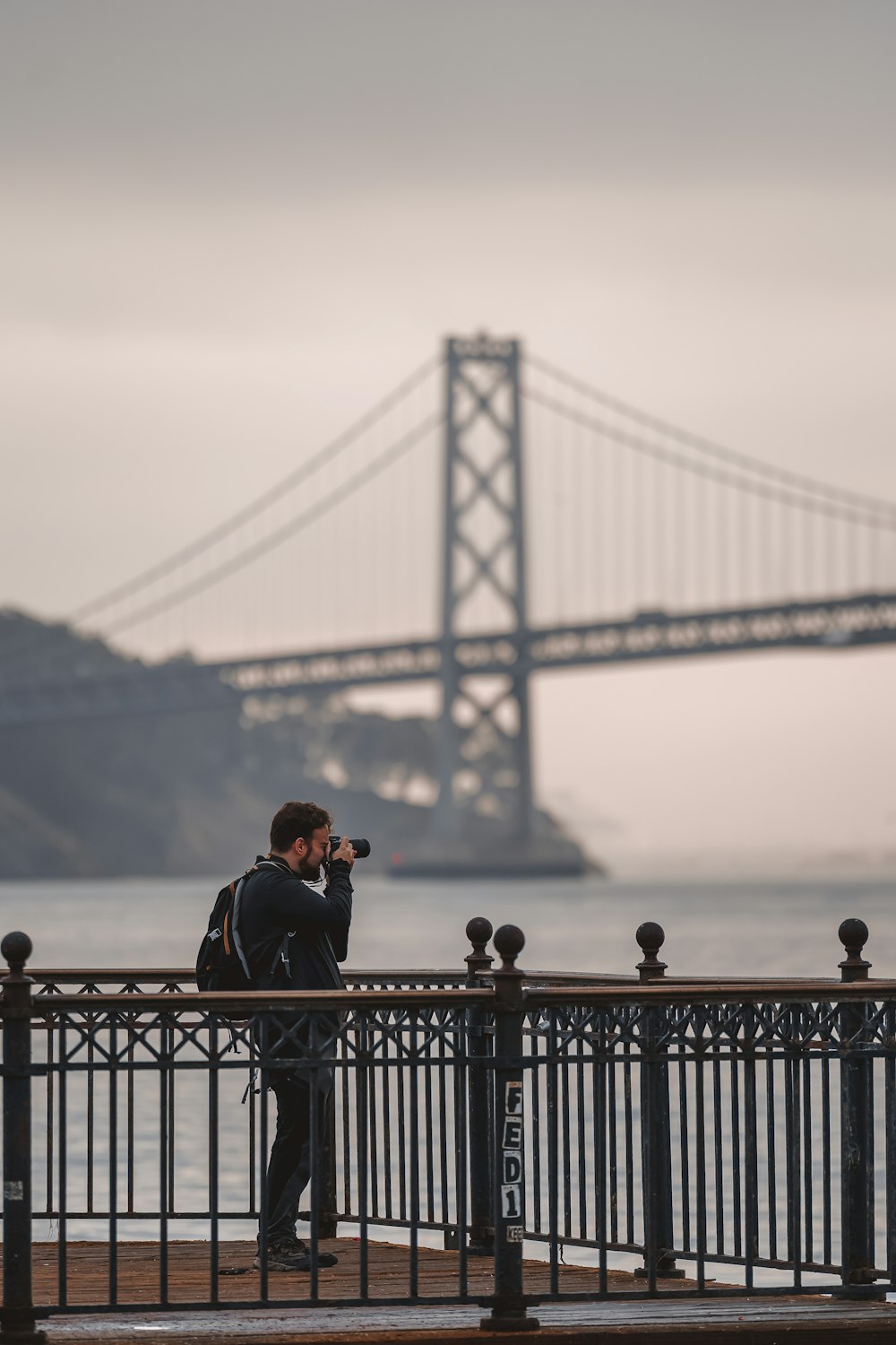 a man taking a picture of a bridge