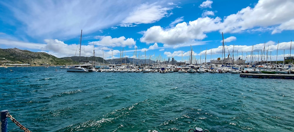 um corpo de água com barcos e montanhas ao fundo