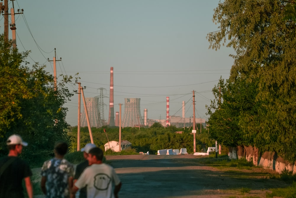 a group of people walking on a road with power lines above
