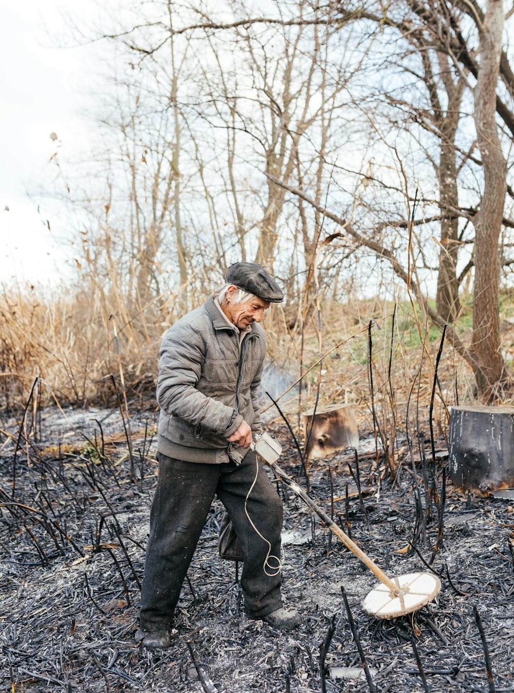 a man with a stick and a dog in the woods