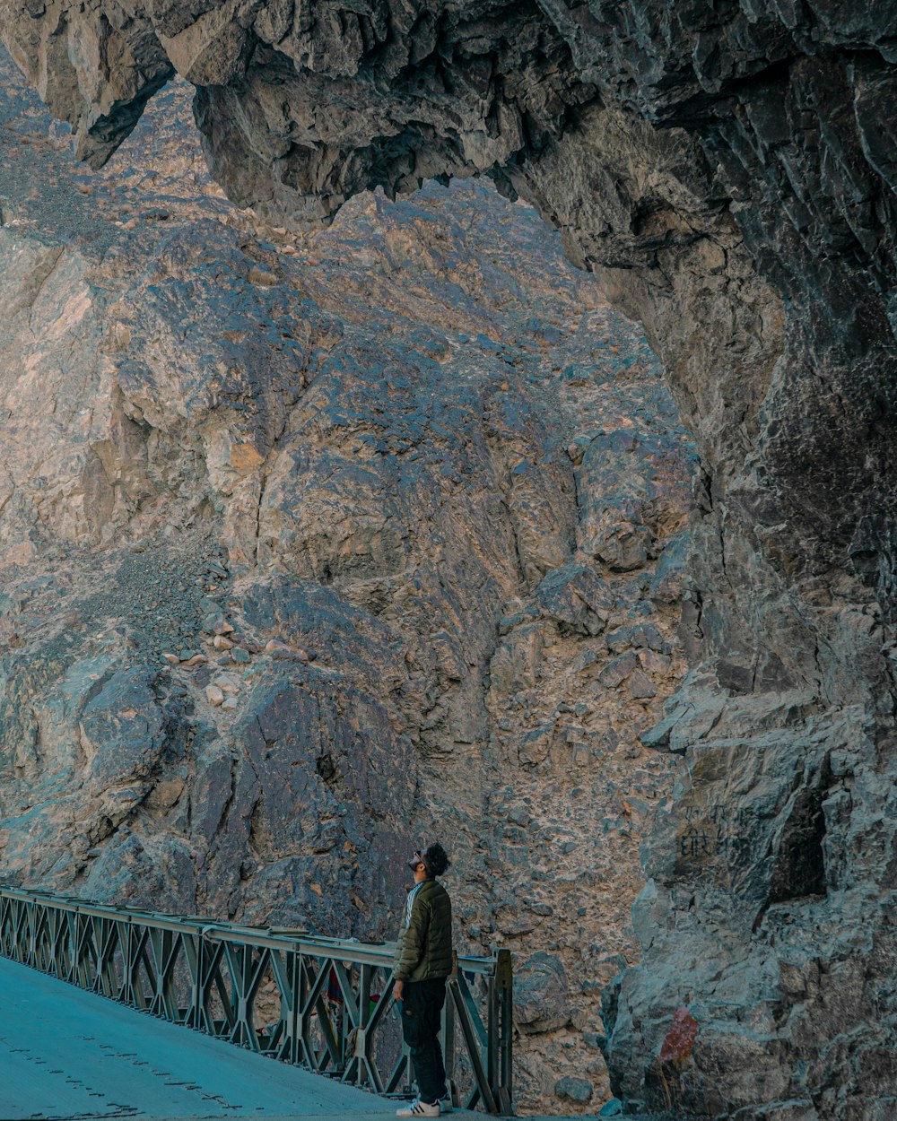 a person standing on a bridge in a cave