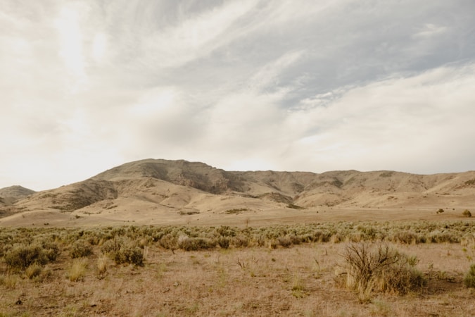 Open Southern Nevada desert land with mountains in the distance, similar to the raw acreage sold for Monument Hills